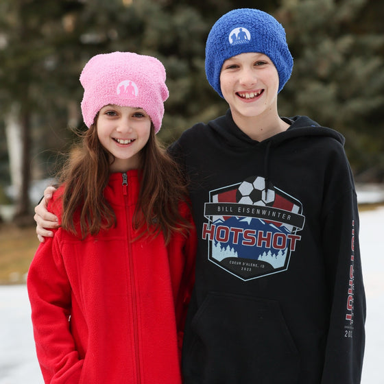 children wearing the pink and blue beanies