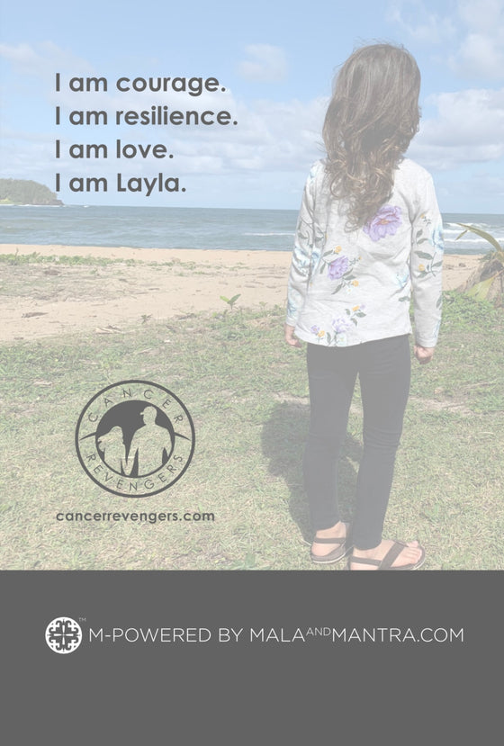 A picture of Layla on the beach with the caption "I am courage. I am resilience. I am love. I am Layla."